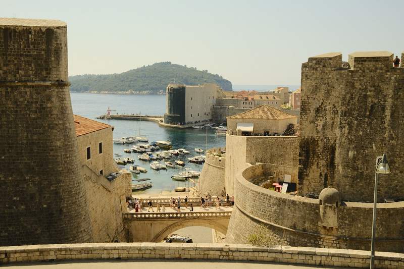 A steep stepped street in Dubrovnik, with stone buildings on both sides.