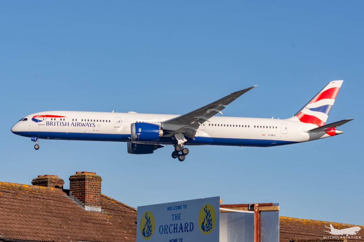 A British Airways Boeing 787-10, registered G-ZBLC, climbing after takeoff with the nose raised and the landing gear still down.