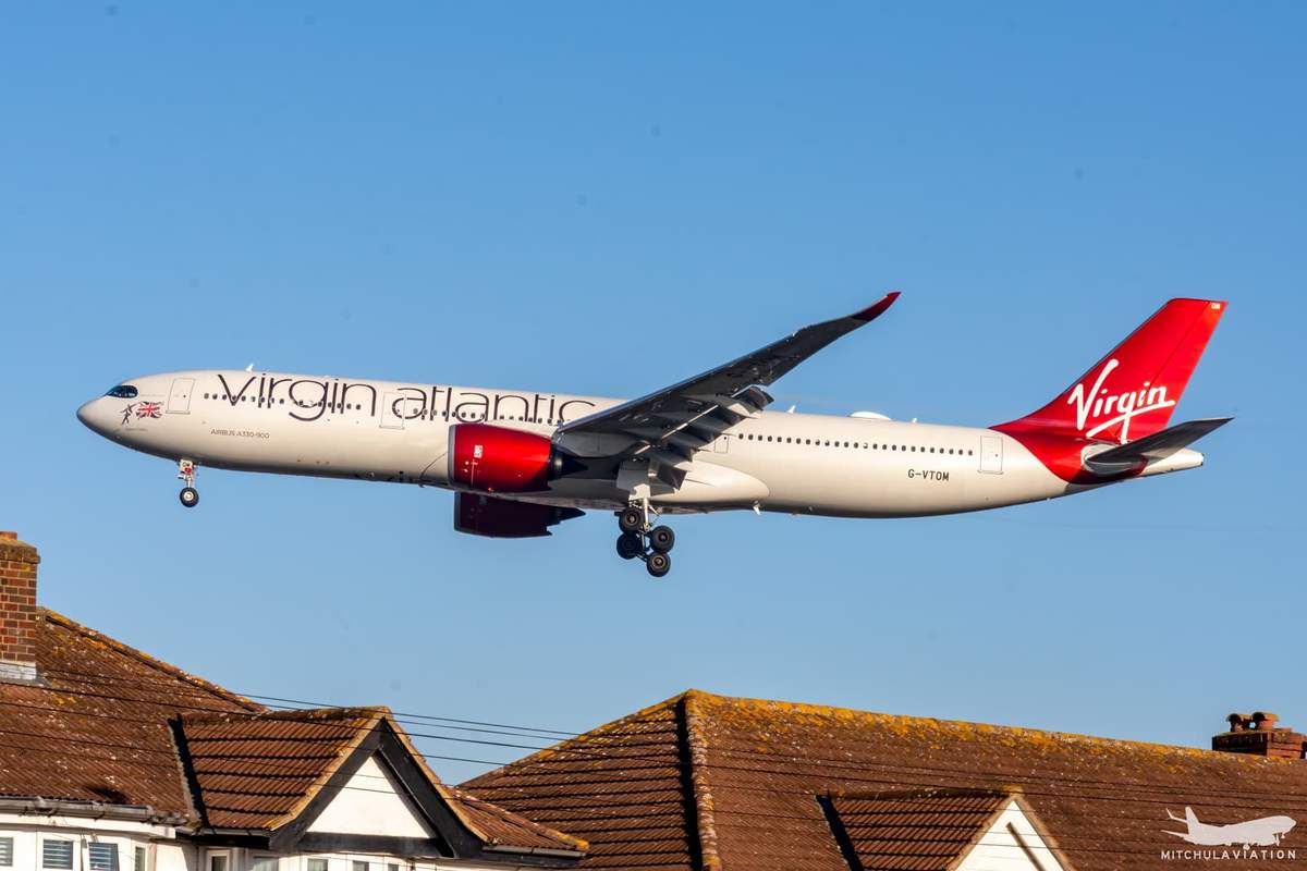 A Virgin Atlantic Airbus A330neo in white and red, climbing after takeoff with the landing gear still down.